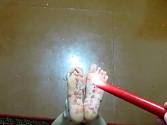 Een volwassen stelletjes zelfgemaakte voetfetisj met kietelen en waxspel