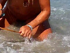 Donna matura con piercing ai capezzoli allargati e piercing alla figa multipli sulla spiaggia