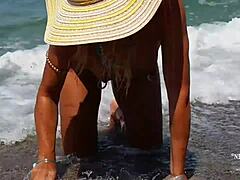 Rijpe vrouw met uitgerekte tepelpiercings en meerdere kutjes piercings op het strand