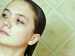 Une magnifique mannequin brune se baigne dans une douche chaude