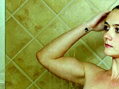Atrakcyjna brunetka modelka kąpie się pod gorącym prysznicem
