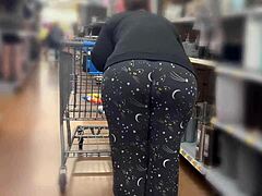 En kurvet mor med en stor rumpe går på shopping i Walmart