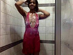 青い肌の熟女が湿ったシャワーを浴びて、ピンクのネクタイを履いて遊びます