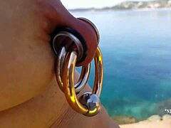 Kinky milf med pierced brystvorter og fitte blinker utendørs på stranden