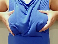 Žena v košili smyslně dojí velká prsa